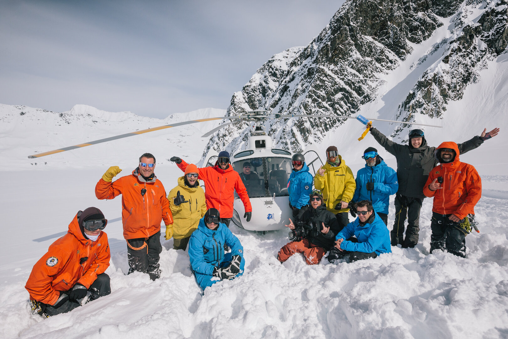 Guides and guests lined up in front of the helicopter on the glacier